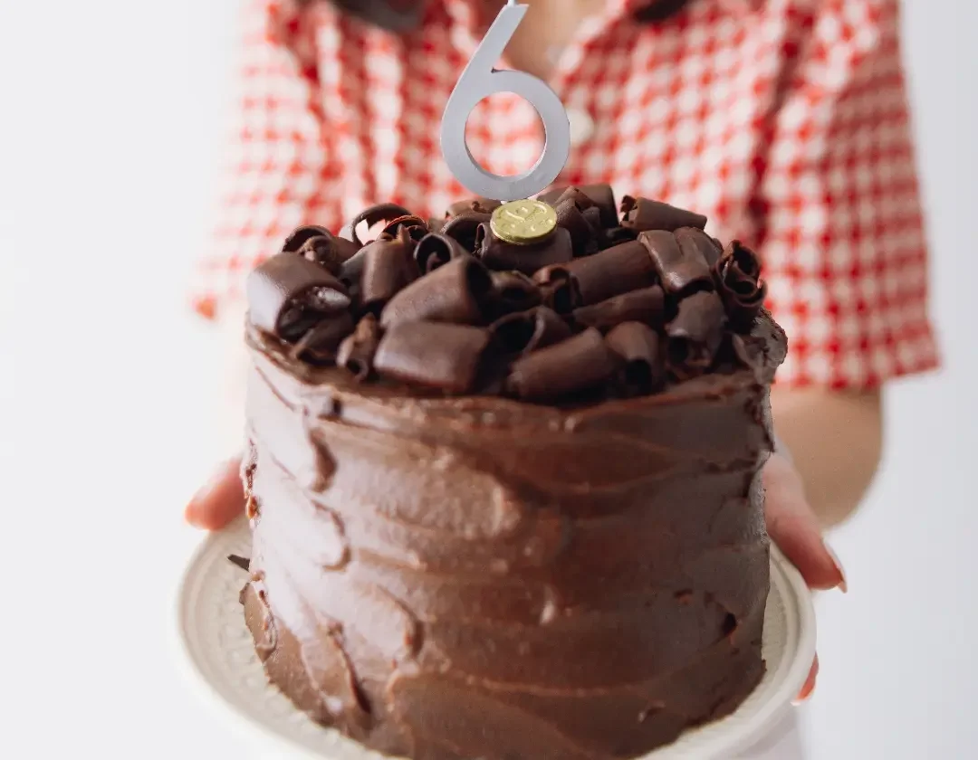 Bolo de chocolate com raspas e vela de número 6 na comemoração dos seis anos da Salva Doces
